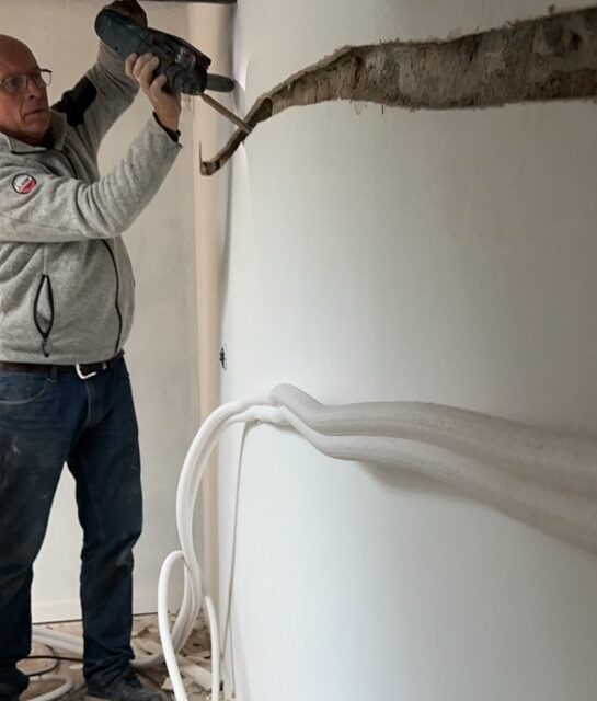Image représentant l'artisan EURL FORIEN en train de travailler sur un mur pour l'installation d'une climatisation.